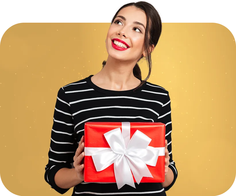 Mujer sonriente con regalo navideño en manos, representando alegría y promociones especiales de Presta Prenda en joyas de oro.